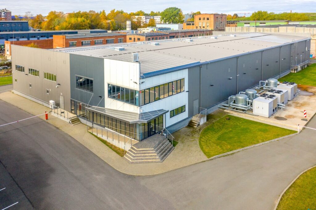View from above of the outside of a data center building with blue sky and green trees in the background.