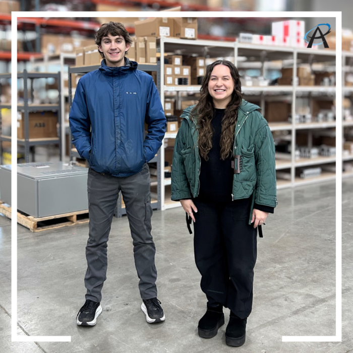 Two team members stand in front of shelves in the warehouse